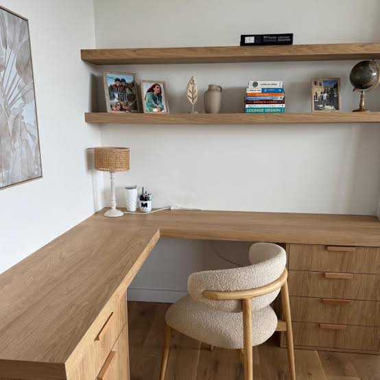 Escritorio de madera a medida con baldas en la pared