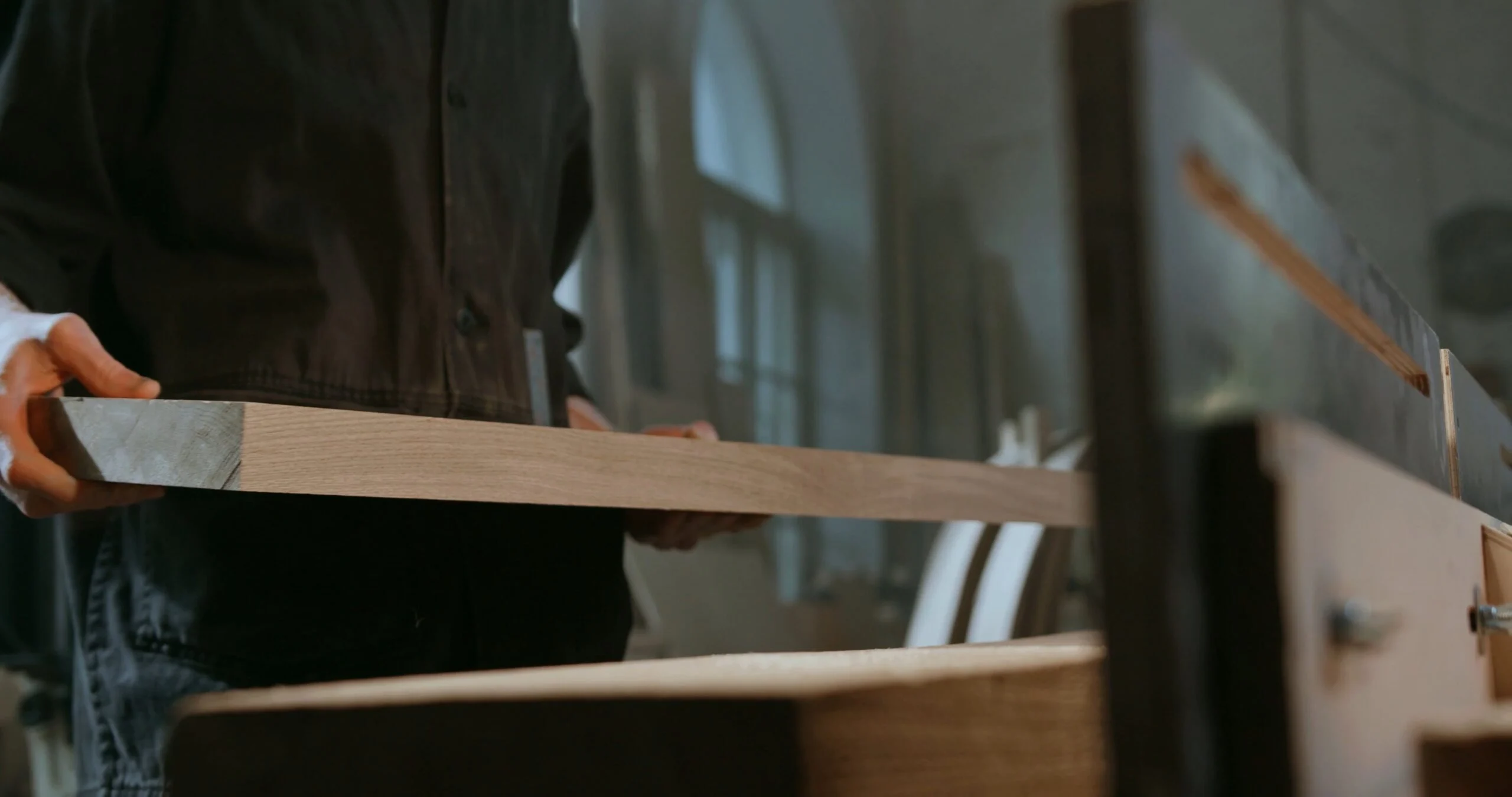Carpintero con una tabla de madera cortada en el taller de Maderas Lamelas